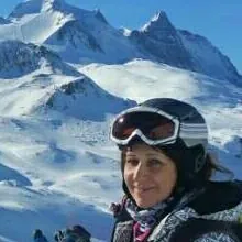 A skier in goggles and helmet on a snowy mountain